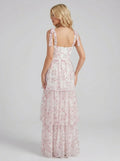 Back view of a woman in a white and pink floral print tiered maxi dress