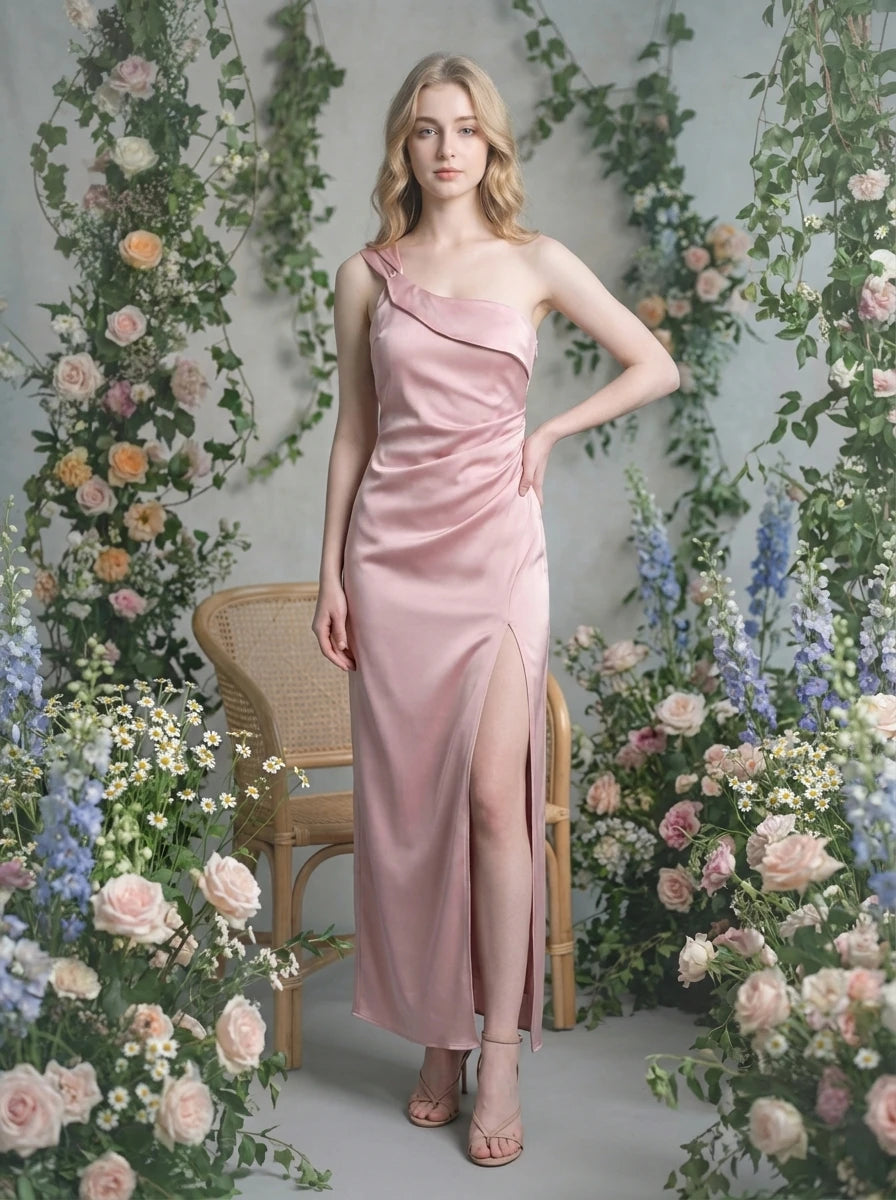 Woman in a dusty rose satin one-shoulder maxi dress with a high slit, posing in a floral garden setting.