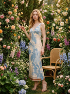 Woman wearing a sleeveless floral print midi dress surrounded by flowers.