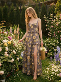 Woman in a grey floral print maxi dress with ruffles and a high slit, walking through a garden.