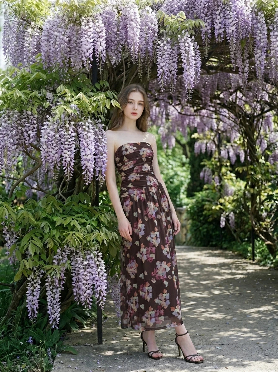 Woman in a strapless floral print chiffon maxi dress under wisteria