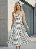 Woman in a white polka dot A-line dress with a V-neckline