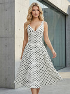 Woman in a white polka dot A-line dress with a V-neckline