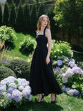 woman in a black midi halter dress in an outdoor setting