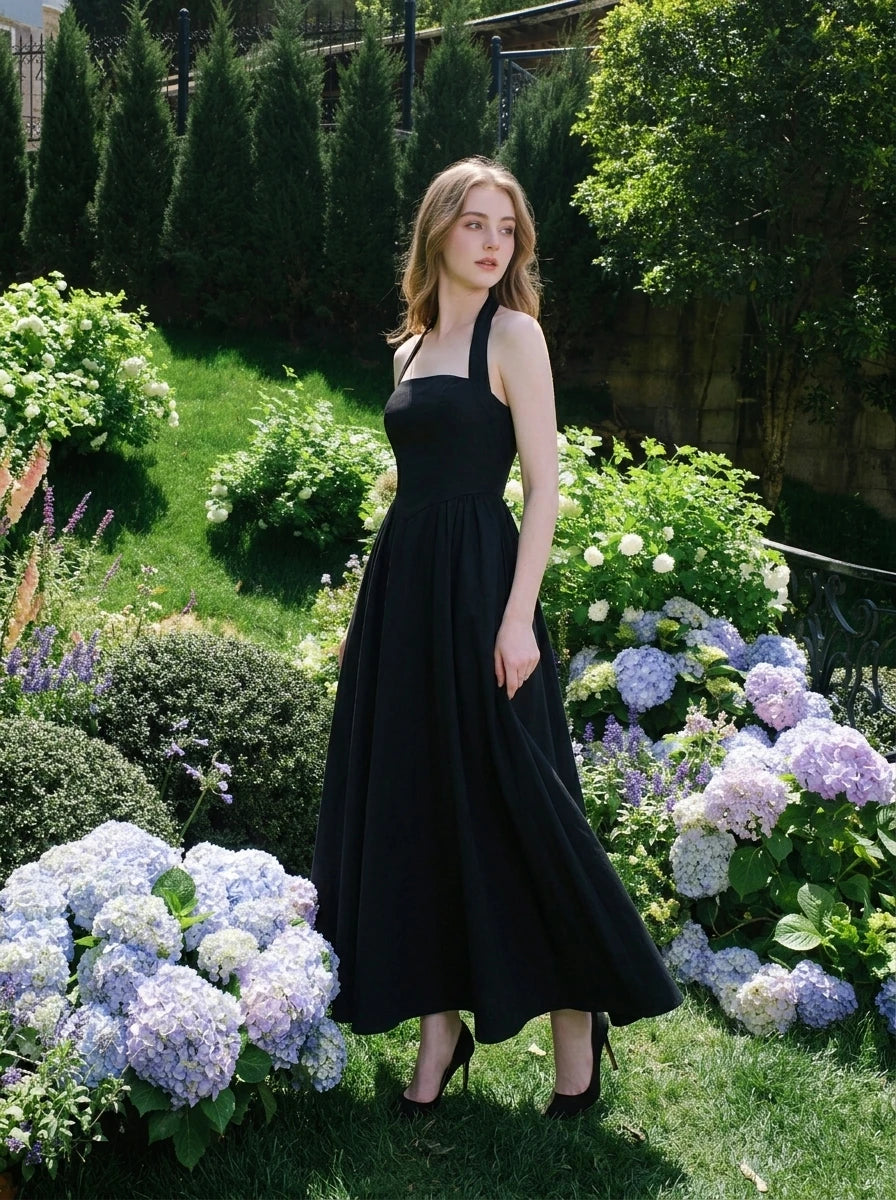 woman in a black midi halter dress in an outdoor setting