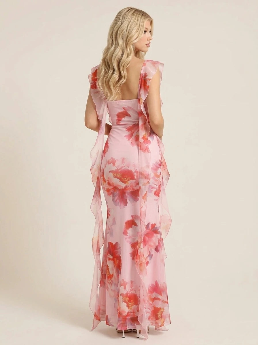 Woman wearing a pink floral print chiffon maxi dress with ruffle trim and a square neckline