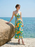 Woman in a strapless floral print midi dress on a rocky beach