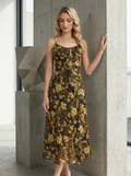 Woman standing next to a concrete column in a floral print chiffon midi dress.