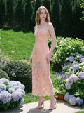 woman wearing a peach floral lace sheath dress standing in a garden with hydrangeas