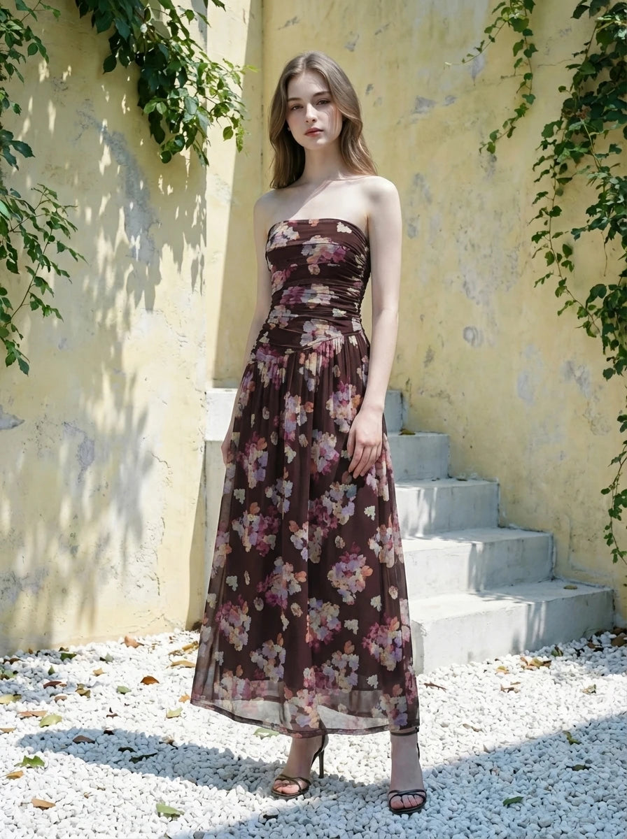Woman in a strapless floral print chiffon maxi dress standing on steps