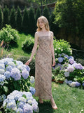 Woman posing in a garden wearing a strapless geometric print maxi dress