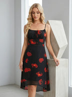 Woman posing in a black floral print midi dress with spaghetti straps and a flowing skirt