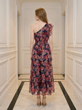 Rear view of a woman in a navy floral print one-shoulder midi dress with a tiered skirt.