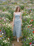Woman walking through a field of flowers in a light blue floral print midi dress
