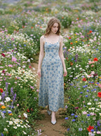 Woman walking through a field of flowers in a light blue floral print midi dress