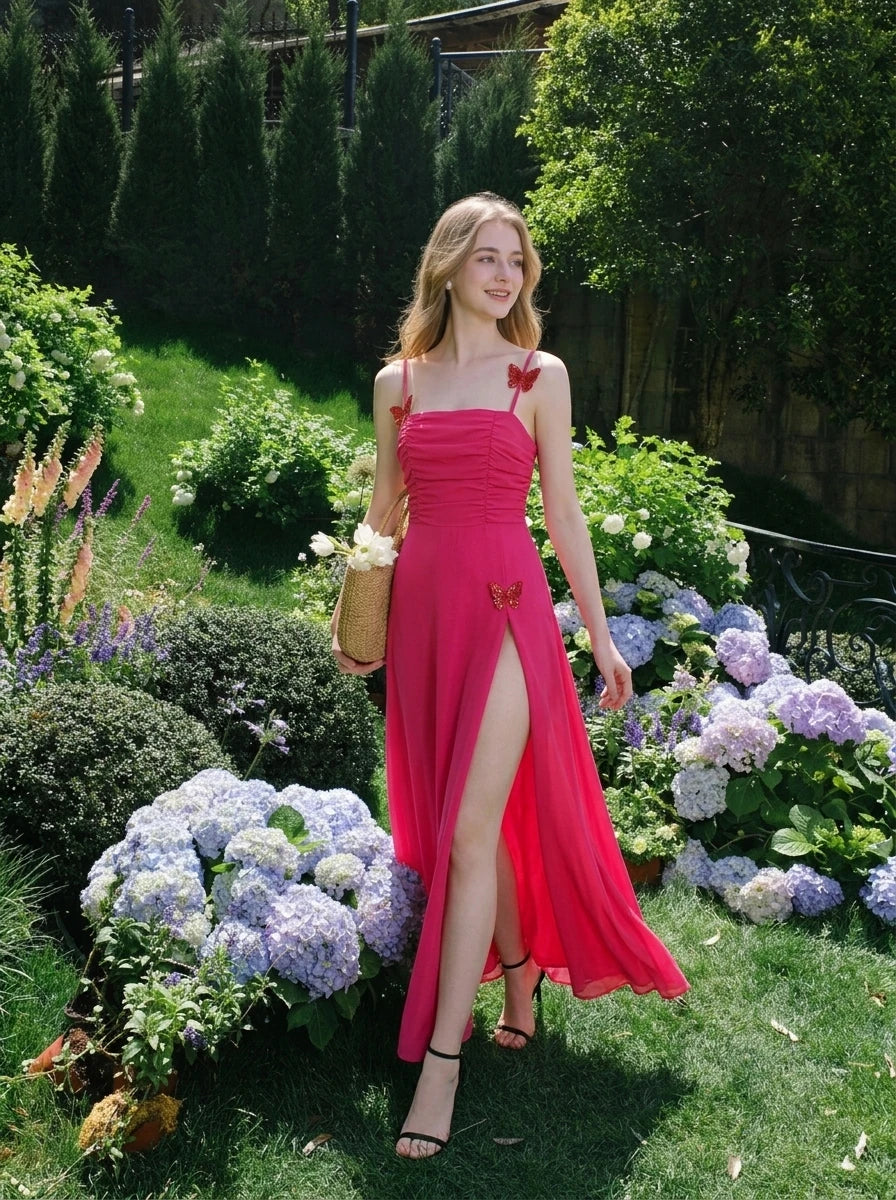 Woman in a bright pink ruched maxi dress with spaghetti straps and butterfly details, walking through a garden with hydrangeas.