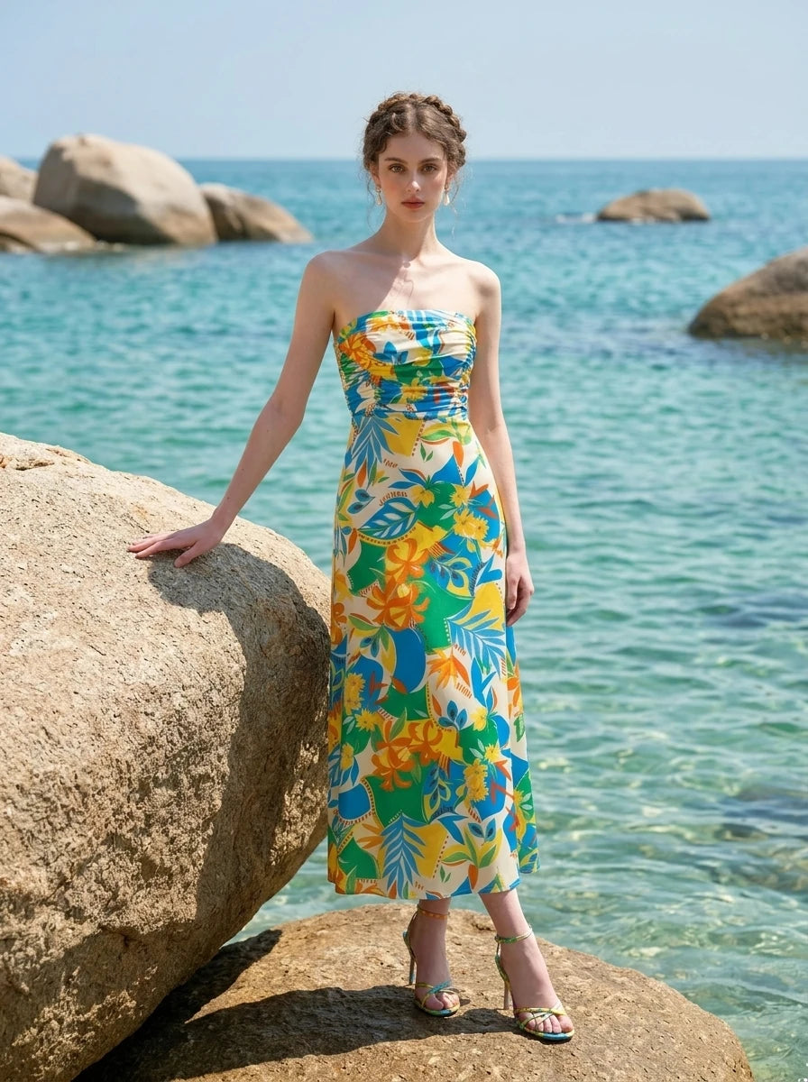 Woman in a strapless floral print midi dress posing by the ocean