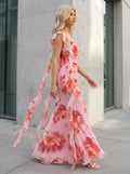 Woman walking outdoors in a pink floral print chiffon maxi dress with ruffle trim