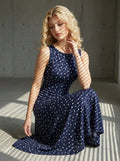 Woman posing in a navy blue polka dot midi dress
