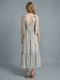 Back view of a woman in a floral print midi dress with tie shoulder straps