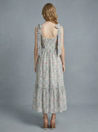 Back view of a woman in a floral print midi dress with tie shoulder straps