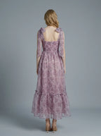 Back view of a floral print A-line dress with tiered hem