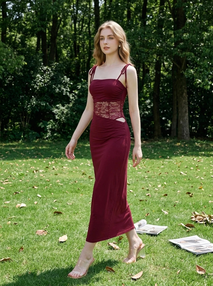 Woman walking in a park wearing a burgundy midi dress with lace accents.