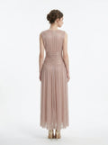 back view of a woman in a rose gold metallic a-line maxi dress with a v-neckline and ruched empire waist