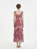 Back view of a woman in a floral print chiffon maxi dress with ruffled neckline and tiered skirt
