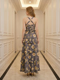Back view of a woman in a grey floral print maxi dress with a lace-up back detail.
