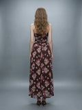 Back view of a woman in a strapless floral print chiffon maxi dress