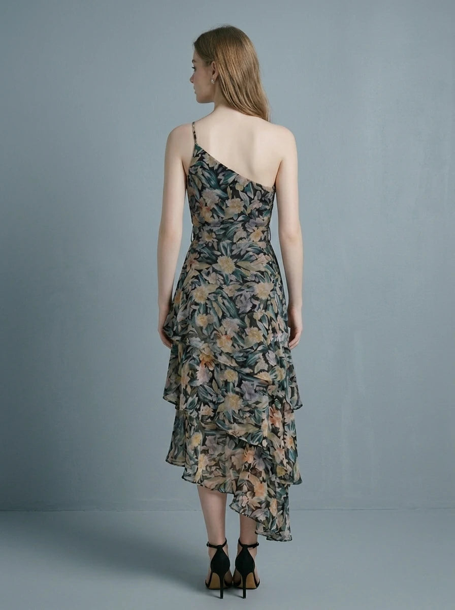 Woman wearing a floral print one-shoulder chiffon dress with a tiered, asymmetrical ruffle skirt.