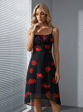 Woman standing indoors wearing a black floral print dress with a sweetheart neckline and spaghetti straps