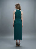 Back view of a woman in a dark green sleeveless halter neck sheath dress with ruched detailing and a high slit