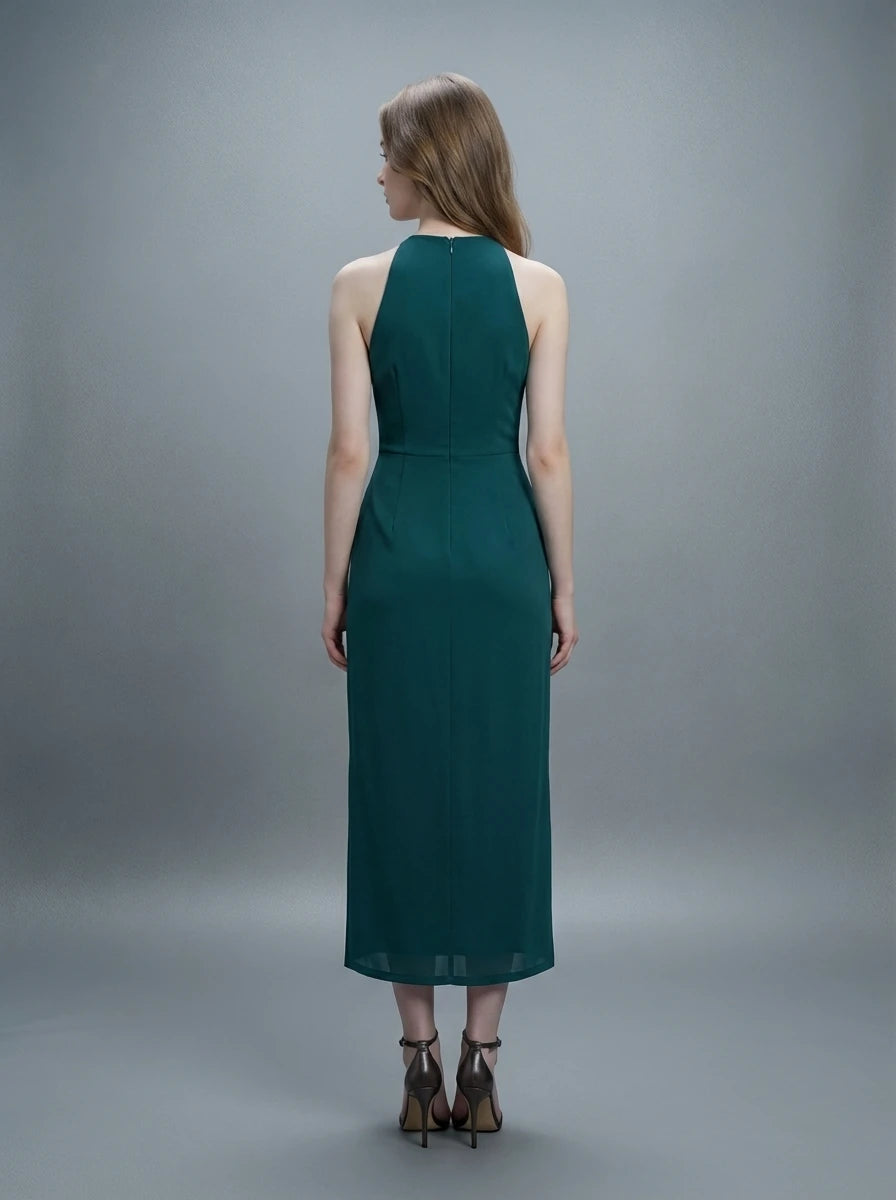 Back view of a woman in a dark green sleeveless halter neck sheath dress with ruched detailing and a high slit