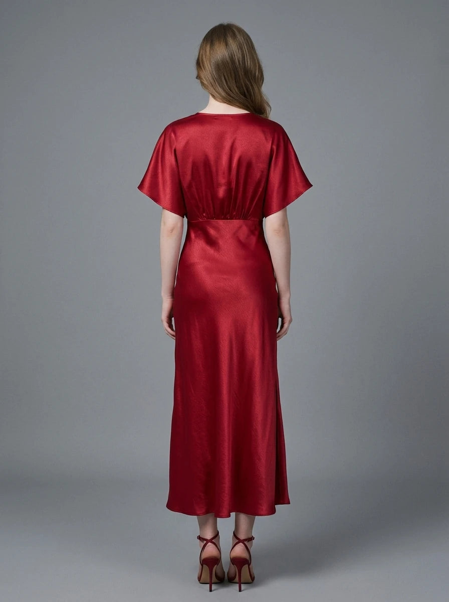 Woman in a red satin V-neck dress with kimono sleeves and a high slit, front view
