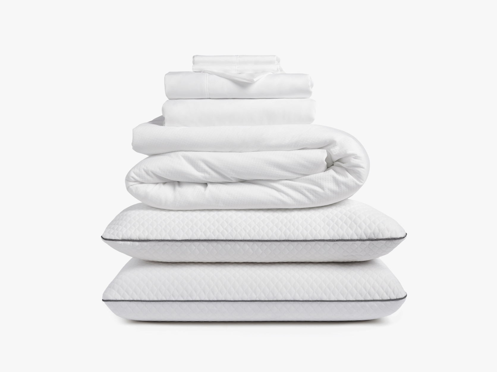 Stacked white bedding including sheets, duvet, and pillows