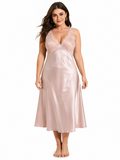 Plus size model wearing a blush pink satin midi slip dress with lace trim on the neckline and back.
