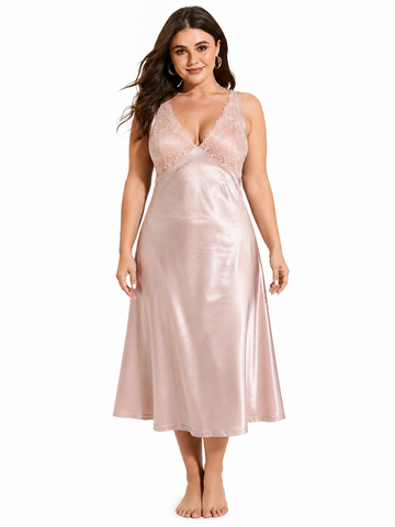 Plus size model wearing a blush pink satin midi slip dress with lace trim on the neckline and back.