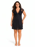 Woman wearing a black lace-trimmed chemise from the front.