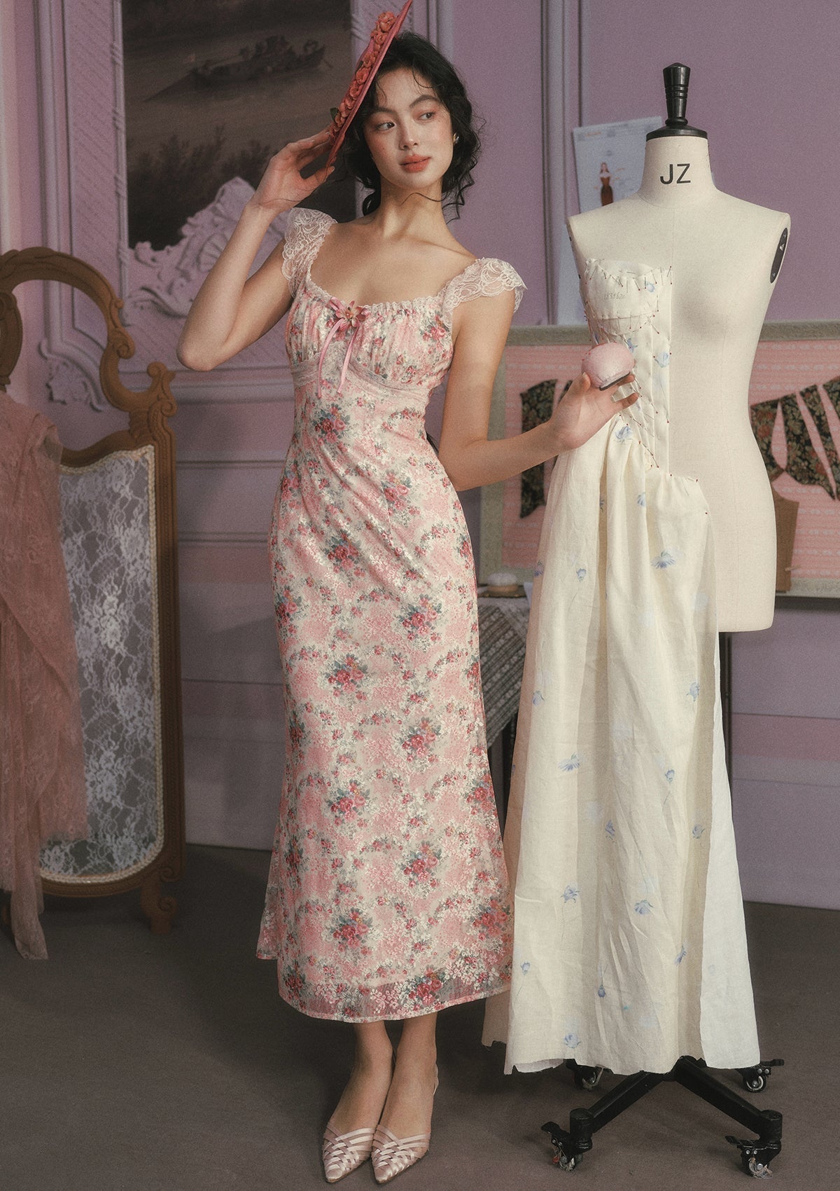 Woman wearing a pink floral print midi dress with lace trim and a pink hat.