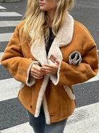 Detail of the button and trim on a faux suede shearling aviator jacket.