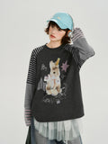 Woman wearing a dark grey long sleeve t-shirt with a graphic print of a bunny and stars.