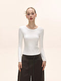 Close-up of the white long-sleeve top's fabric texture.