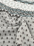 Close-up of the textured knit fabric of a grey sweater with a Fair Isle pattern