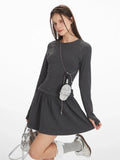 Close-up of a woman posing in a dark grey ribbed drop waist mini dress.
