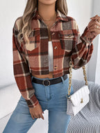 Close-up of a woman wearing a plaid cropped shirt jacket and blue jeans, accessorized with a gold necklace and a white handbag