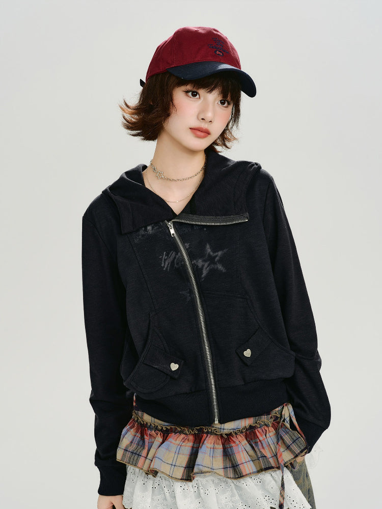 Woman wearing a black zip-up hoodie with the hood down, displaying the graphic print and front pockets.