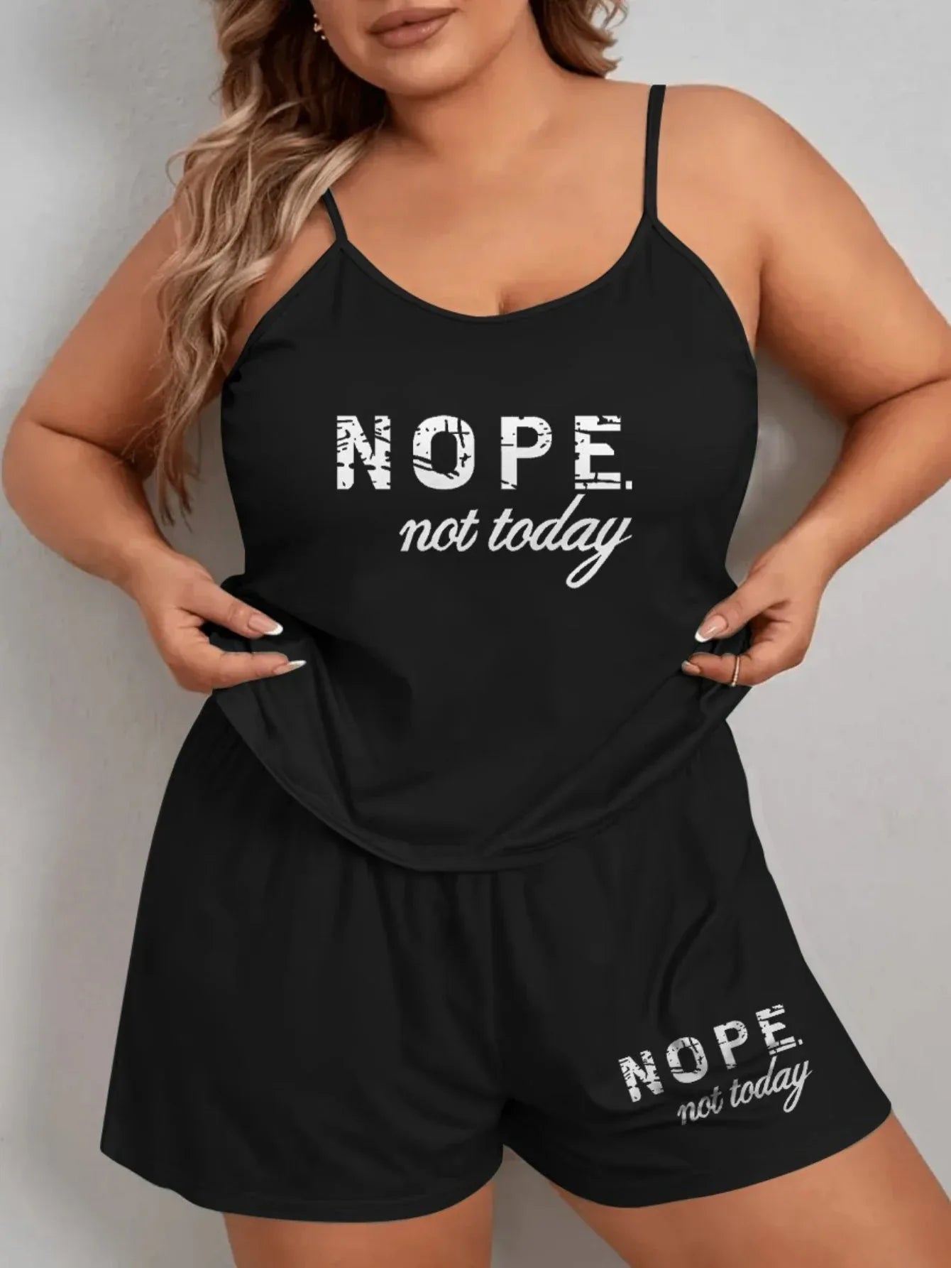 Woman wearing a black pajama set with adjustable spaghetti straps