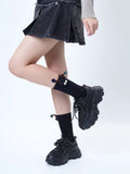 Model wearing black crew socks with a creature applique